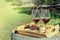 Wine tasting. Two glasses of red wine with snacks on a barrel outside a winery, with blurred greenery in the background