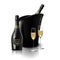 Wineglass with black wine bottles of champagne in a bucket