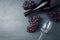 Wineglass, bottle and ripe grapes on black stone background.