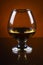 Wineglass of cognac on a orange gradient background