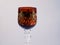 wineglass red gold colored white background close-up