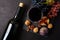 Wineglass with red wine, bottle, grapes, figs and walnuts lying on dark wooden background. Top view.