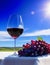 Wineglass with red wine and grapes on a background of green field