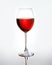 Wineglass with red wine on light gray background