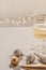 Wineglass with sparkling wine on beige table, blurred Christmas decoration ornaments on foreground, blurred garland
