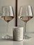 Wineglasses with champagne and candle in the white table