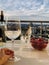 Wineglasses with champagne and strawberries with  hands  in the background blue sea