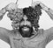 Winegrower with cheerful face holds clusters of grapes up. Viticulture and gardening concept. Man with beard holds