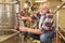 Winemaker checks wine at fermentation tank in winery