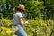 Winemaker Farmworker, Woman with brown hair and straw hat checking the quality of her Wine Plants