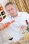 Winemaker pouring wine to glass in wine cellar