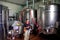 Winemaker standing next to stainless steel fermentation vessels