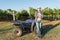 Winemaker in straw hat standing near quad bike