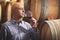 Winemaker tasting red wine in front of wine barrels