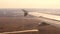 Wing of aircraft in front of warm color sunset sky