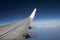 Wing of an airliner plane in flight. Blue sky.