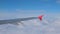 Wing airplane and cloud on sky. View through an airplane window.