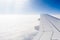 Wing of airplane flying above the clouds at high altitude. Travel, acrophobia concept. Copyspace.
