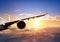 Wing of airplane flying above clouds in sunset light