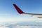 Wing of an airplane flying above the morning clouds and Andean mountain range