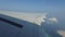 Wing of airplane flying above ocean