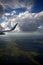 the wing of an airplane flying through the air in front of clouds