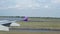 Wing of an airplane taxi runway and turn around in Airport, shot from the window of the plane