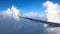 Wing of airplane from window, amazing white cumulus clouds and atmospheric deep blue sky. Descent before landing, flying through t