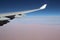 Wing of a jet plane and aerial view of Sahara desert.