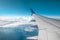 A wing of a modern passenger airplane above the clouds. International cargo transportation, air travel, transport. Copy space