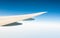 Wing of plane over white clouds. Airplane flying on clear blue sky. Scenic view from airplane window. Commercial airline flight.