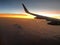 The wing of a plane in the sunset