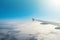 Wing view of the airplane, fluffy clouds on the skyline during climbing flight level.