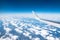 Wing view of the airplane on a winglets and jet engine, fluffy clouds on the skyline during climbing flight level.