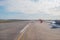 Wing view runway at the airport sky and a airplane taking off in the distance.