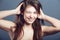 Wink, face and beauty portrait of a woman in studio with a smile, makeup and hands in hair. Headshot of a happy female