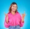 Wink, portrait and woman with rocker hands in studio for freedom, happy and positive attitude on blue background. Smile