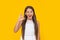 winking teen girl in white dress has long hair on yellow background