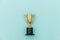 Winner or champion gold trophy cup  on blue pastel colorful background