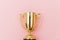 Winner or champion gold trophy cup isolated on pink pastel colorful background
