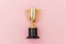 Winner or champion gold trophy cup  on pink pastel colorful background