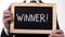 Winner exclamation written on blackboard in businessman hands, successful person