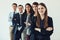 Winners focus on winning. Studio shot of a group of confident young businesspeople standing together in a row.