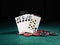Winning combination in poker standing leaning on chips piles on green cover of playing table. Black background. Close-up