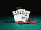 Winning combination in poker standing leaning on colored chips piles on green cover of playing table. Black background