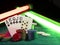 Winning combination in poker standing leaning on colorful chips piles on green cover of playing table, under green and