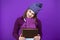 Winsome Adult Caucasian Woman in Warm Knitted Hat and Purple Scarf Posing with Big Wrapped Giftbox Whie Embracing Box With Both