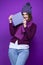 Winsome Adult Caucasian Woman in Warm Knitted Hat and Purple Scarf Posing with Big Wrapped Giftbox Whie Smiling Happily With Eyes