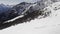 Winter aerial over group of people with snowshoes hiking down a snowy slope. Winter wonderland panorama with active