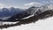 Winter aerial over group of people with snowshoes hiking down a snowy slope. Winter wonderland panorama with active